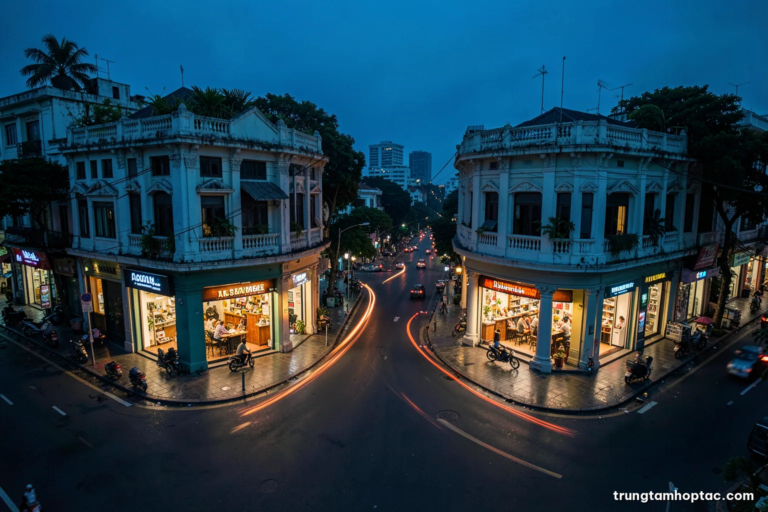 Aerial view of a Saigon street intersection at blue hour with two contrasting corner shops lit from inside, motorbike light trails between them, deep blue and orange palette