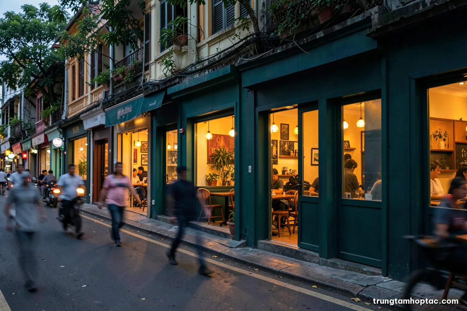 Wide shot of a row of identical small cafe storefronts along a Hanoi street at dusk, warm interior lights glowing, pedestrians blurred in motion, teal and amber palette