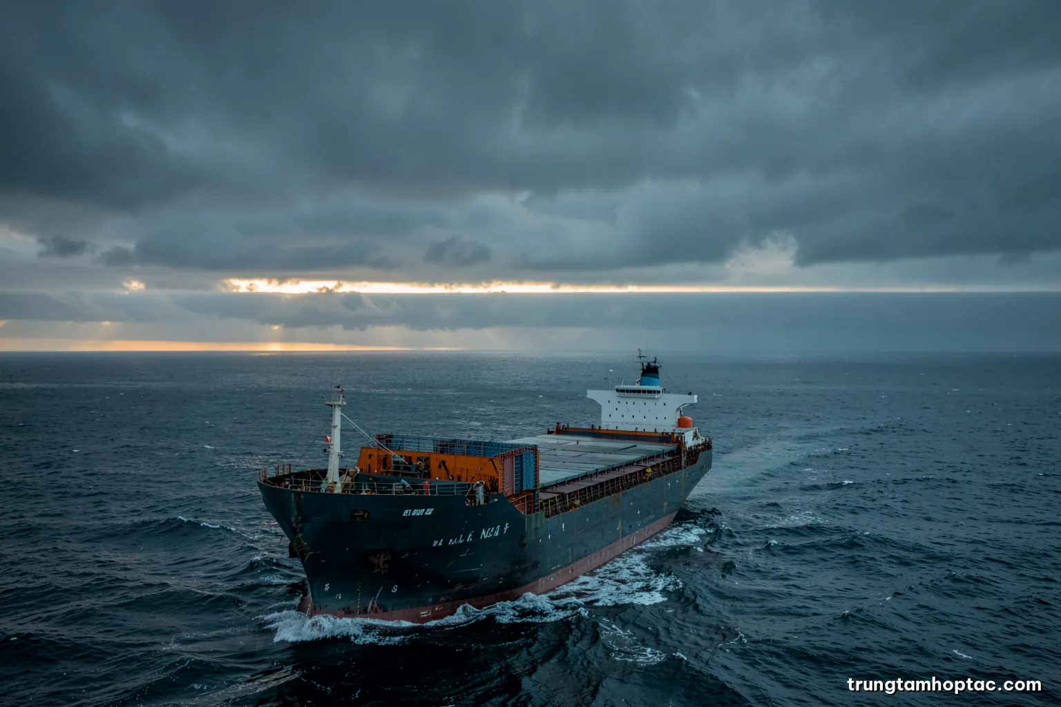 Wide high angle view of a cargo ship sailing through a stormy grey sea, dark clouds and a narrow band of light on the horizon, desaturated steel blue palette